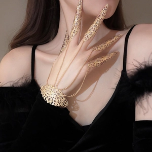 Detailed close-up of exotic hollow flower hand chain with golden gothic finger rings