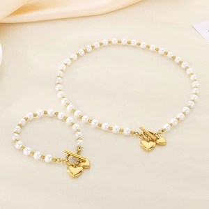 Detail of pearl and gold bead jewelry set with double heart pendants and OT toggle clasp
