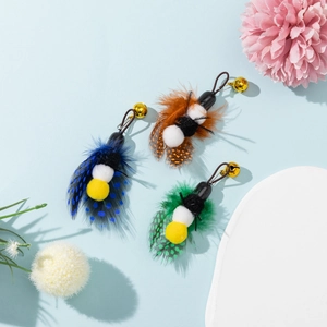 Three-pack of feather cat toy replacements with metal bells on a soft blue backdrop
