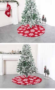 Detail of red plush Christmas tree skirt with white snowflake patterns in cozy setting
