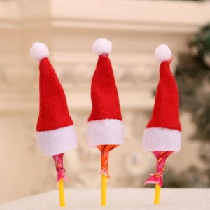 Close-up of three mini red and white non-woven Christmas hats used as lollipop toppers