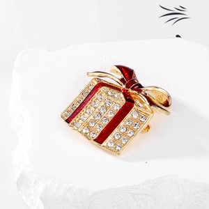 Close-up of red enamel Christmas gift box brooch with sparkling crystal rhinestones
