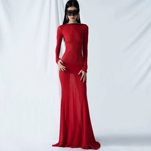 Detail of red sheer mesh long sleeve dress showing textured tulle and black trim accents