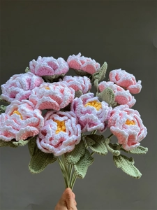 Detailed view of hand-knitted pink and white peony crochet bouquet with realistic textures
