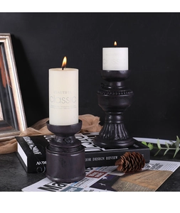Détail des bougeoirs noirs rétro avec bougies piliers blanches sans fumée et décor