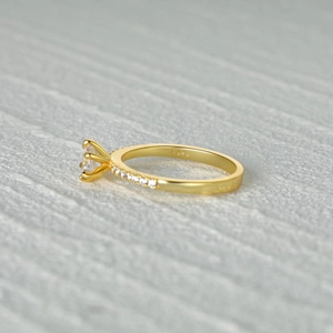 Macro shot of S925 sterling silver gold ring with classic four-prong diamond setting