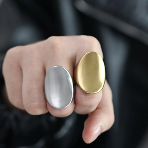 Minimalist large oval stainless steel ring with brushed texture worn by a model