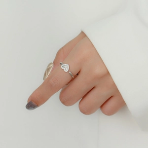 Close-up of heart-shaped silver ring with sparkling micro-diamonds on a hand