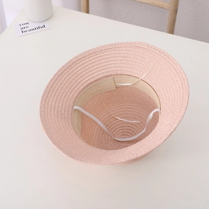 Detail of pink straw hat showing inner sweatband, adjustable drawstring, and fine weave texture
