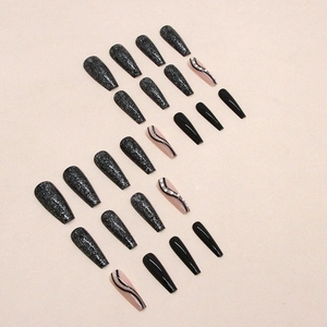 Long coffin press-on nails with black glitter, wavy patterns, and rhinestone accents