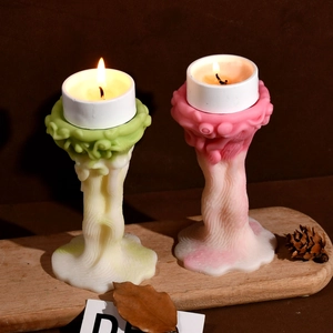 Detalle de portavelas artísticos con textura tejida y velas de té encendidas hoy