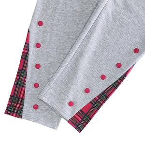 Vue détaillée du pantalon en maille grise avec bouton rouge et surpiqûres à carreaux