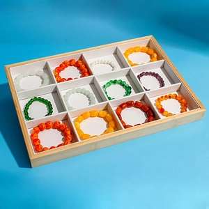 Detailed top view of a 12-slot bamboo jewelry display tray with colorful beaded bracelets