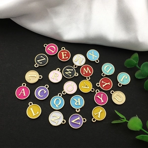 Detailed view of colorful double-sided enamel alloy alphabet charms for DIY jewelry making