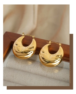 Detailed view of C-shaped gold-plated titanium earrings with unique hammered antler texture