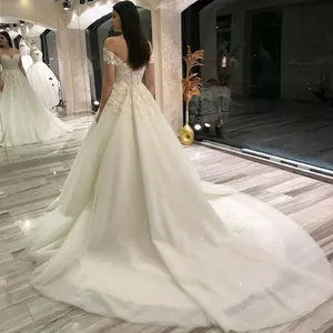 Abito da sposa bianco con spalle scoperte e lungo strascico in tulle scintillante schiena