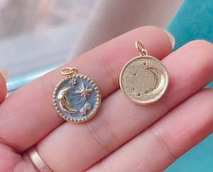 Detailed macro view of the gold celestial pendant featuring blue enamel star and moon design