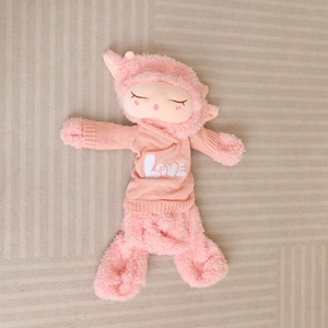 Pink plush sheep doll wearing a knit sweater with LOVE embroidery in a lying position
