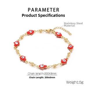 Detail view of gold stainless steel Hamsa hand bracelet with red enamel evil eye charms