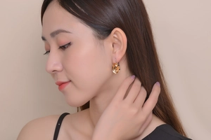 Detailed view of women wearing gold square amber crystal earrings in a chic style