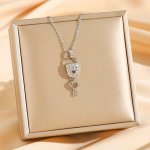 Collier chic avec pendentif clé et cadenas cœur argenté sur un écrin bijoux