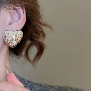 Macro shot of silver heart-shaped earring featuring a unique radiant striped texture
