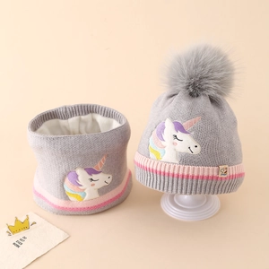 Detail view of unicorn embroidery and fleece lining on the knitted hat and neck warmer
