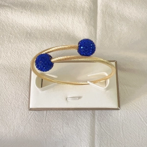 Bracelet torsadé élégant plaqué or 18k avec des sphères en cristal bleu étincelant