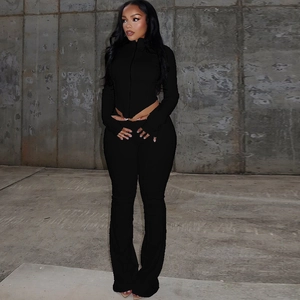 Detail of black long sleeve zip top and high waisted flare trousers sports set