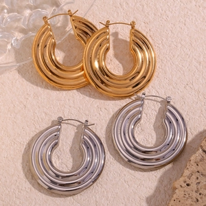 Macro view of ribbed hollow hoop earrings in polished gold and silver finishes