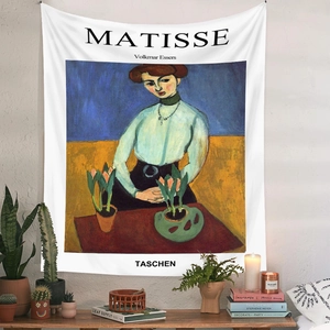 Artistic Henri Matisse style tapestry detail hanging on a white wall with home decor setup