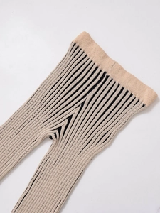Close-up of beige ribbed knit leggings featuring elastic waist and black striped texture