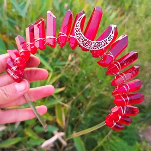 Macro shot of red crystals and silver hollow moon detail on a handcrafted crown headband
