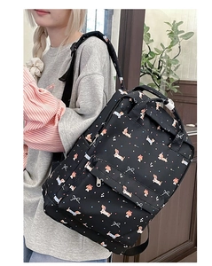 Side view of student backpack featuring cartoon dachshund prints and durable material