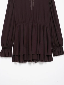 Detail eines dunkelbraunen Chiffonkleides mit elastischer Taille und Rüschensaum