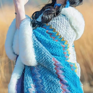 Close-up of blue and purple knitted shawl featuring soft white faux rabbit fur collar