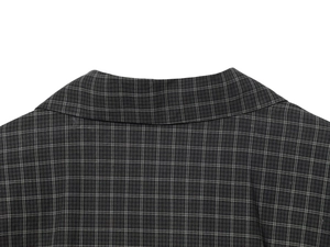 Close-up of the lapel collar and fine woven fabric texture of a dark grey plaid top