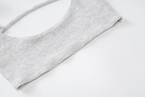 Gros plan sur le tissu en maille côtelée gris clair montrant la texture douce et élastique