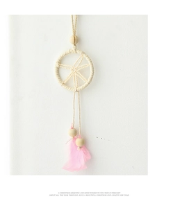Detail of dreamcatcher ornament with pink feathers, cream woven ring and wooden beads