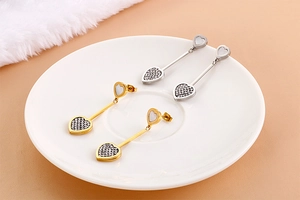 Detail view of heart-shaped drop earrings with mother of pearl and pave crystals
