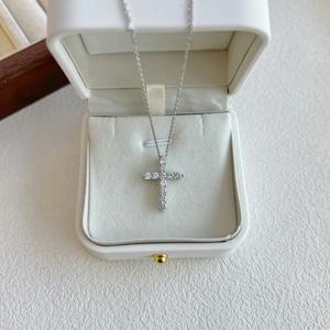 Detail of silver S925 cross pendant necklace with zircon inlay in a white jewelry box