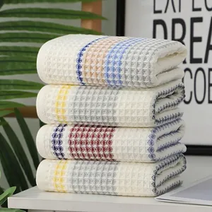 Four-piece waffle weave cotton towels with colored stripes in a fresh Nordic home setting