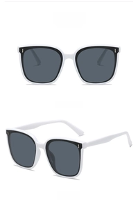 Macro view of white frame sunglasses with gray lenses and metallic side details