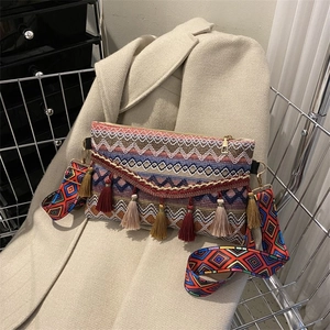 Detail of bohemian knit crossbody bag with vibrant fringe and geometric jacquard strap