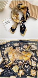 Detailed view of square silk scarf with floral and geometric patterns on wooden tray