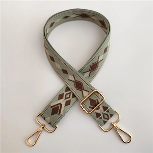 Detail of adjustable green ethnic jacquard bag strap with gold metal lobster clasps