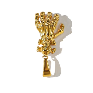 Close-up of a gold stainless steel skeleton hand pendant with detailed bone carving