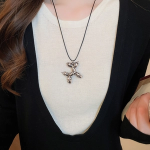 Close-up of balloon dog pendant with leopard print texture on black cord necklace