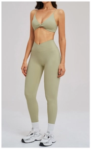 Dettaglio del set yoga verde salvia con reggiseno a V e leggings a vita incrociata