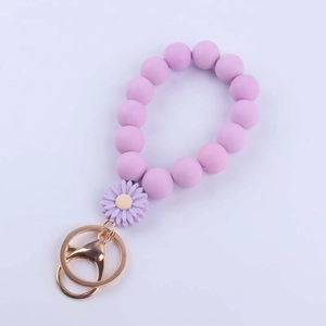 Detailed view of light purple silicone daisy beaded keychain with golden metal clasp